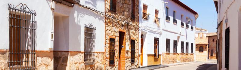 A narrow street lined with white buildings.