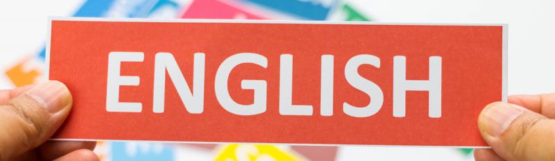 A hand holds a red card displaying the word "English" prominently in white text.