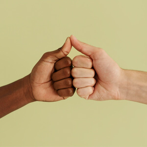 Two hands giving a thumbs up gesture against a vibrant green background.