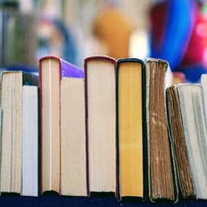 A row of linguistics books displayed on a table in a library setting, showcasing various titles and authors.