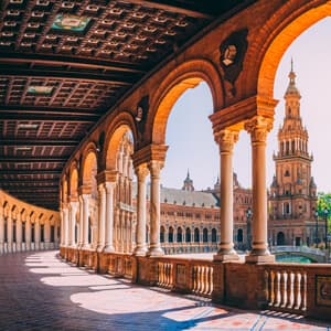A panoramic view of Plaza de España, featuring intricate brickwork, colourful tiles, and serene waterways in Seville, Spain.