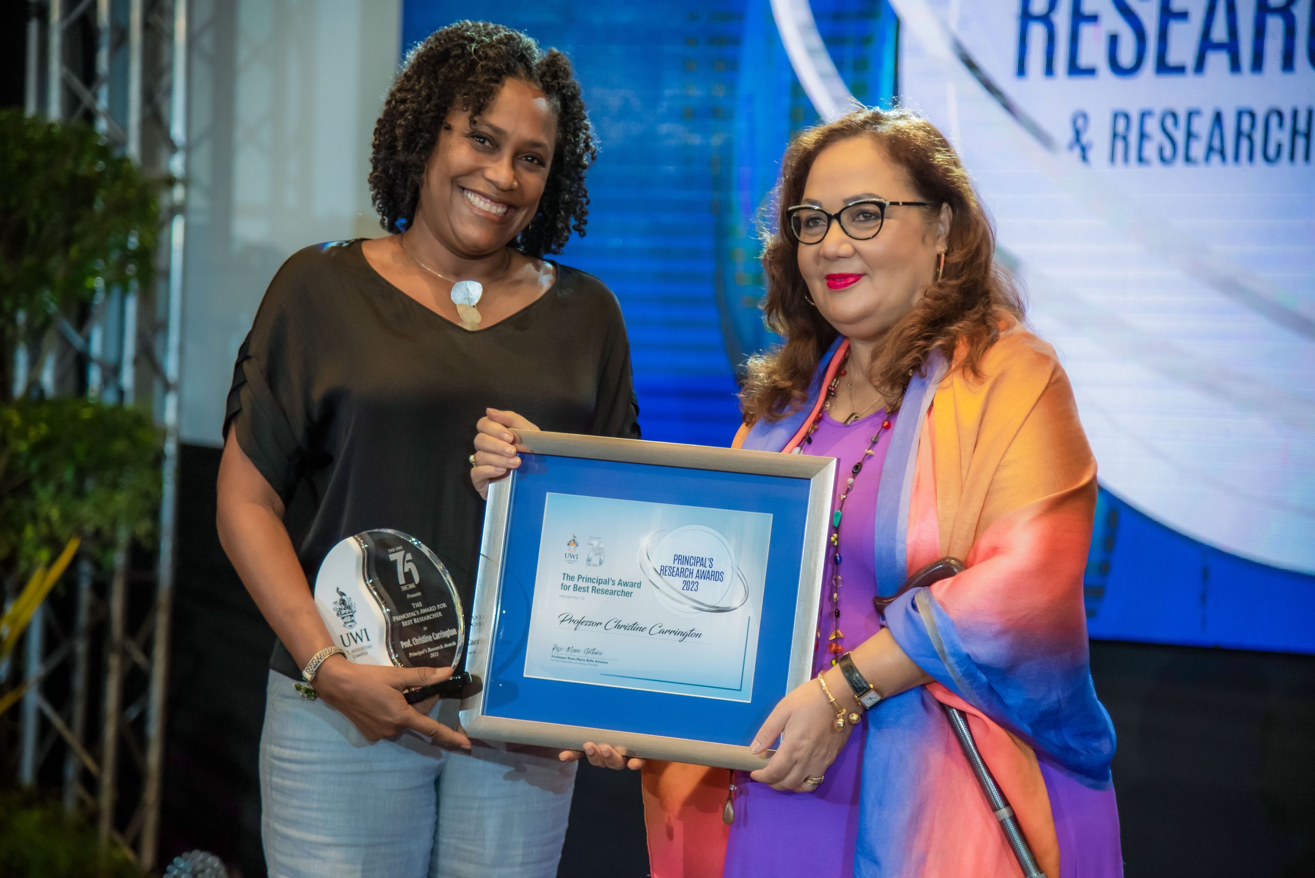 Professor Christine Carrington receiving the 2023 Best Researcher Award from UWI St. Augustine Campus Principal, Rose-Marie Belle Antoine.